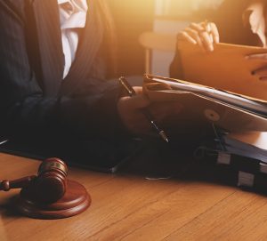 Attractive young lawyer in office Business woman and lawyers discussing contract papers with brass scale on wooden desk in office. Law, legal services, advice, Justice and real estate concept.